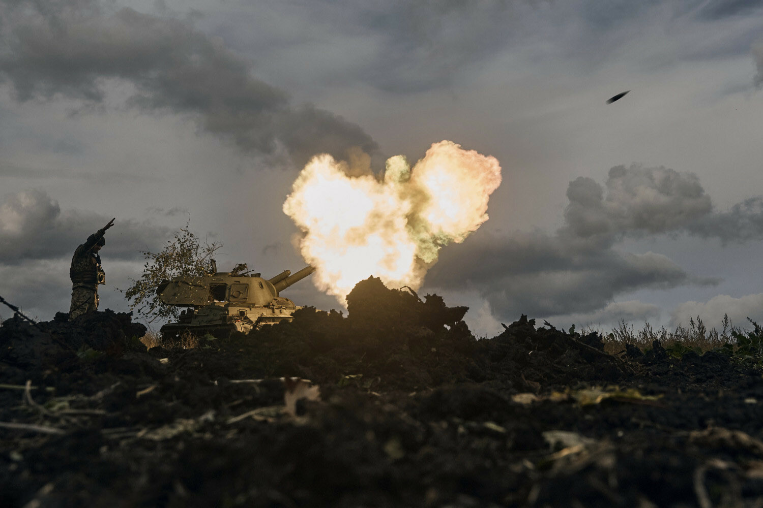 A Ukrainian serviceman reacts as a self-propelled artillery vehicle fires near Bakhmut, Donetsk region, Ukraine, Saturday, Oct. 22, 2022. (AP Photo/LIBKOS)