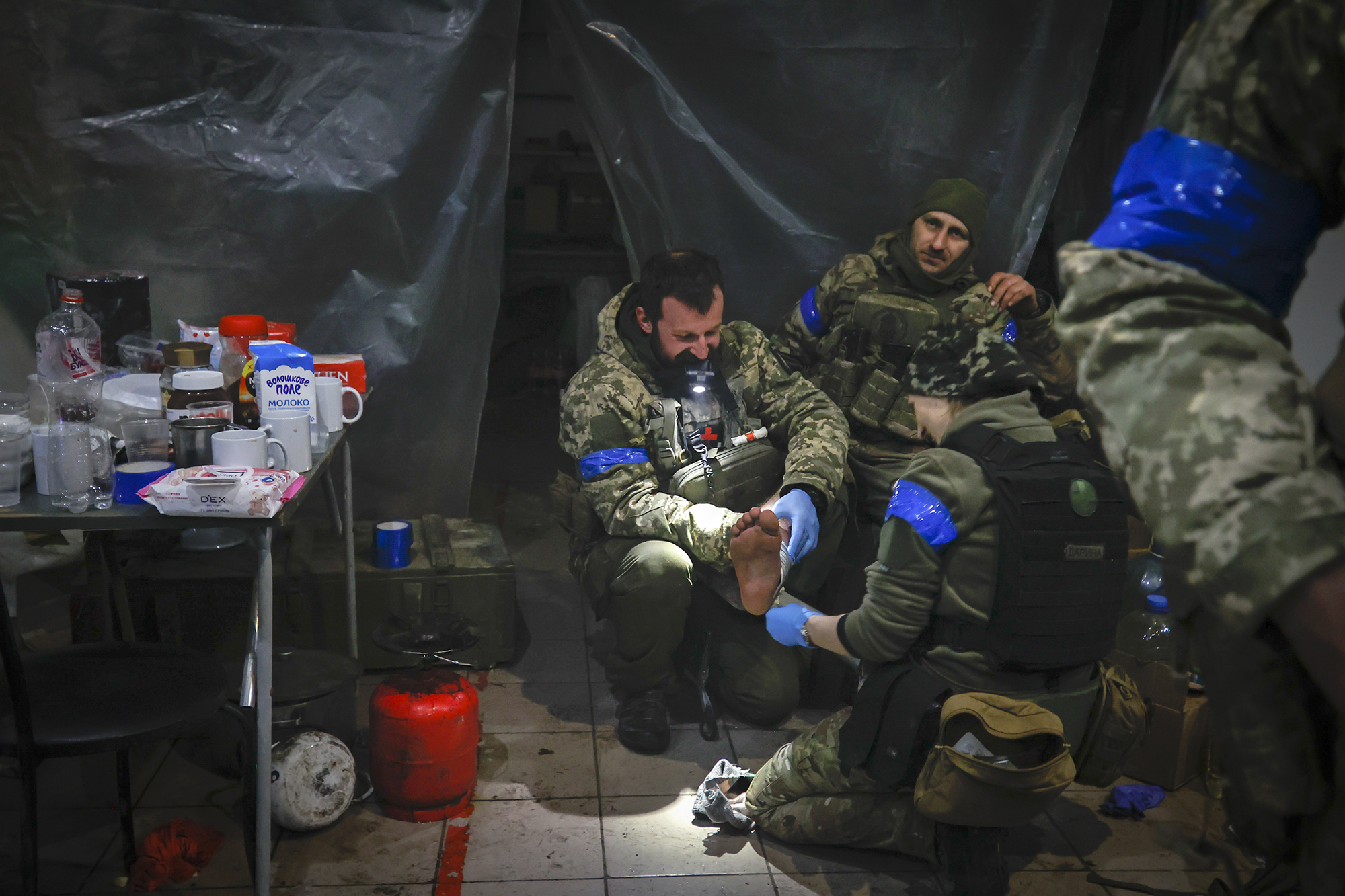 Ukrainian servicemen administer first aid to a wounded soldier in a shelter in Soledar, the site of heavy battles with Russian forces in the Donetsk region, Ukraine, Sunday, Jan. 8, 2023. (AP Photo/Roman Chop)