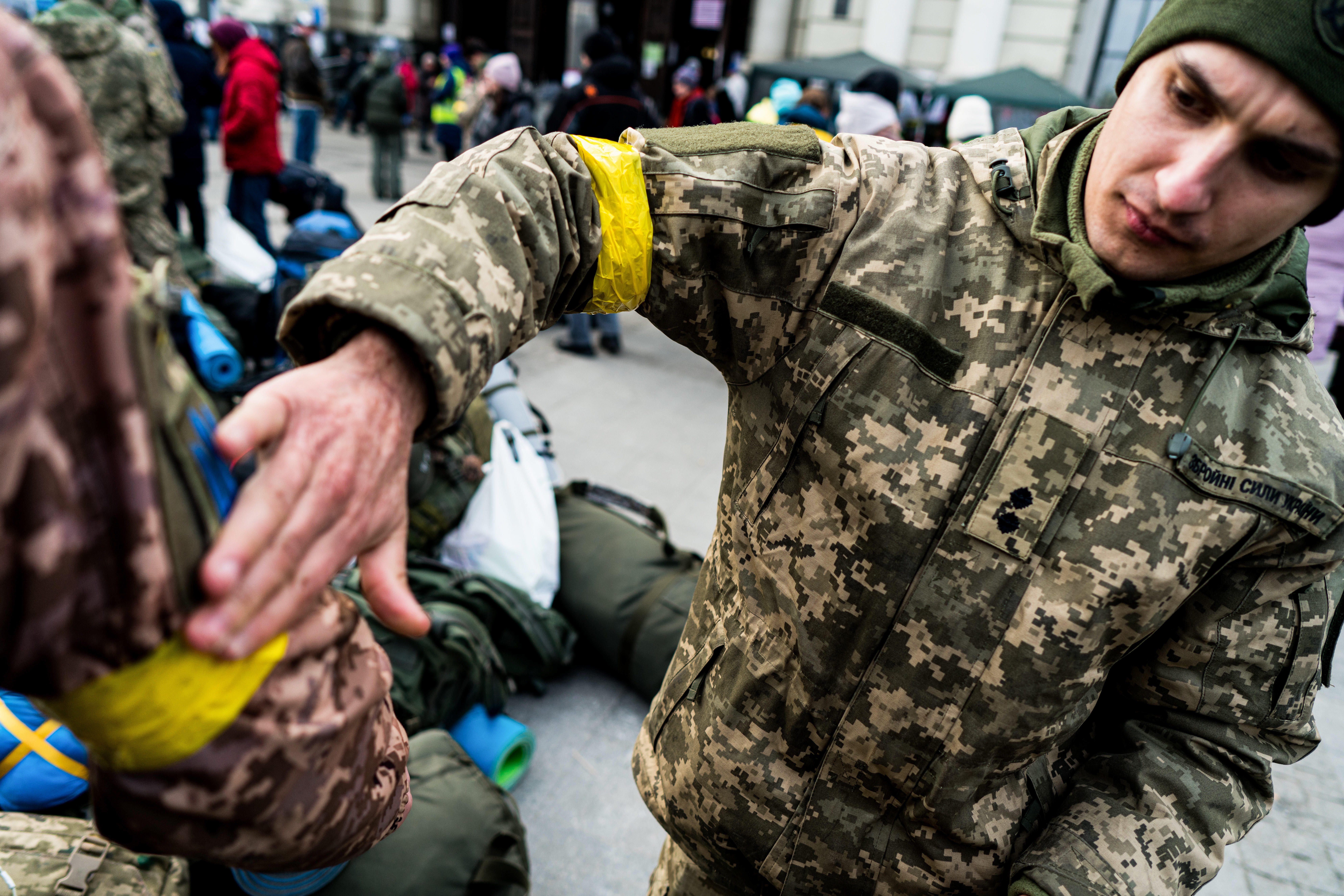 March 9, 2022, Lviv, Ukraine: A soldier putting the yellow ribbon on his comrade-in-arms arm in Lviv..As Russia launched a full-scale invasion of Ukraine, people try to escape the country passing through Lviv, while others get ready to fight the Russian army. (Credit Image: Global Look Press/Keystone Press Agency)
